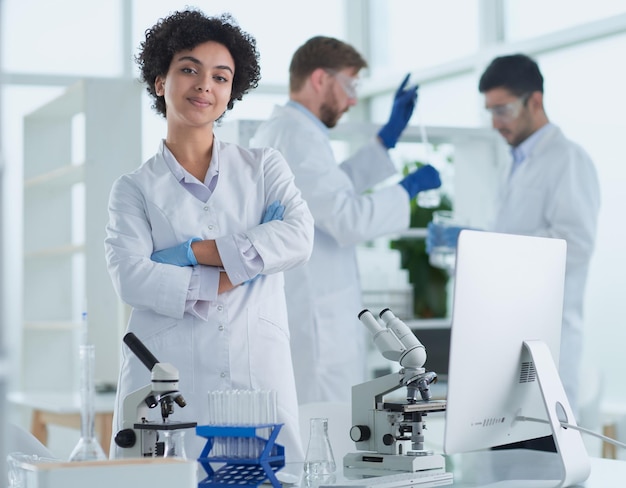 Cientistas sorridentes olhando para os braços da câmera cruzados em laboratório