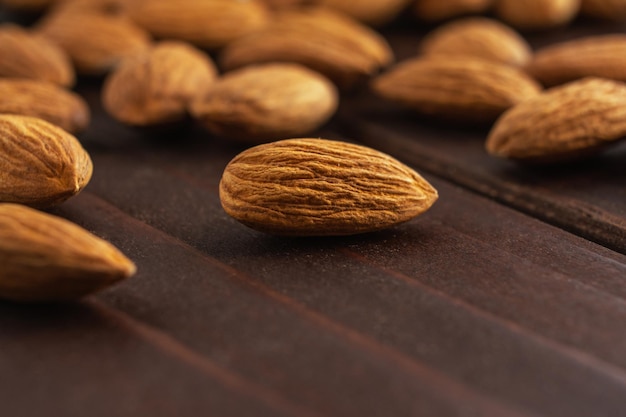 Cierra las almendras en la mesa de madera. Comida vegetariana de proteína de salud orgánica. Espacio de copia de enfoque selectivo