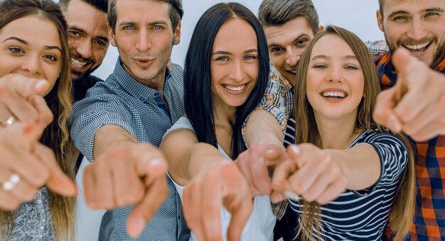 Foto cierra un divertido equipo de jóvenes apuntándote