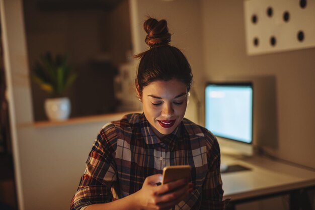 Cierra la foto de una hermosa chica enviando mensajes de texto en su teléfono móvil.