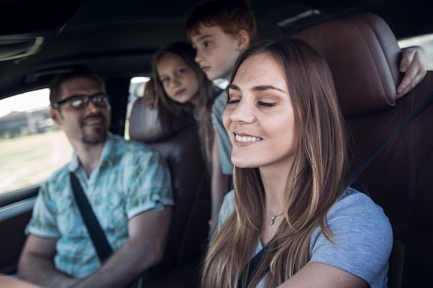 Foto cierra a la joven al volante del coche familiarconcepto de vacaciones en familia