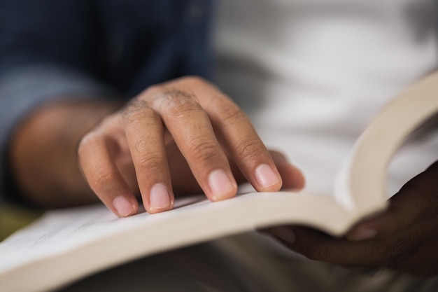 Cierra el libro abierto de la mano masculina y la lectura.