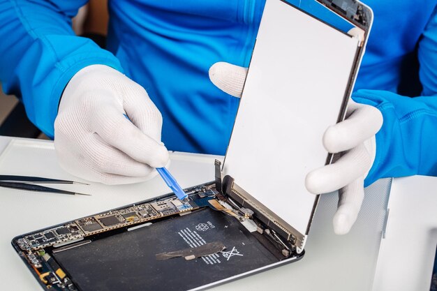 Foto cierra las manos de un trabajador de servicio que repara una tableta moderna