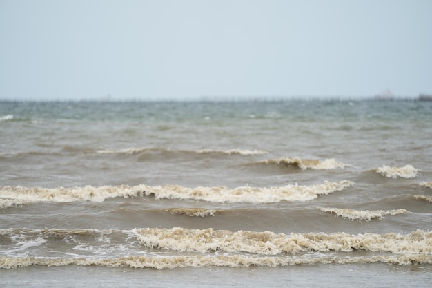 Cierra la ola marrón sucia del mar a la playa