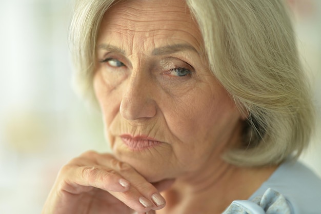 Cierra el retrato de una anciana triste en casa