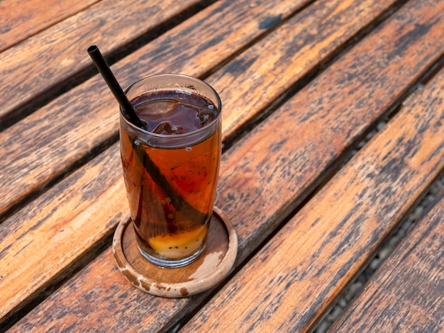 Cierra un vaso de té de lychee fresco en una vieja mesa de madera