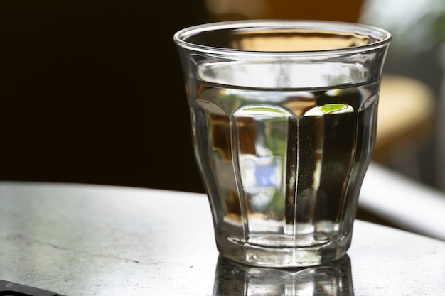 Cierre el agua de bebida fresca purificada de la botella en la mesa en la sala de estar