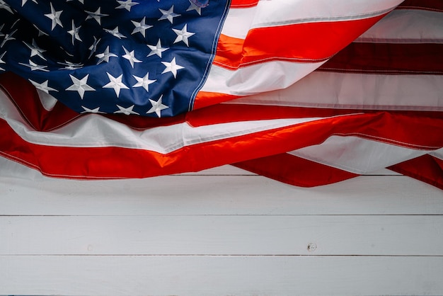 Cierre la bandera americana sobre un fondo blanco de madera con lugar para el texto