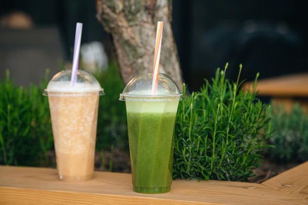 Cierre el batido verde y naranja en la bebida refrescante de la fiesta de verano