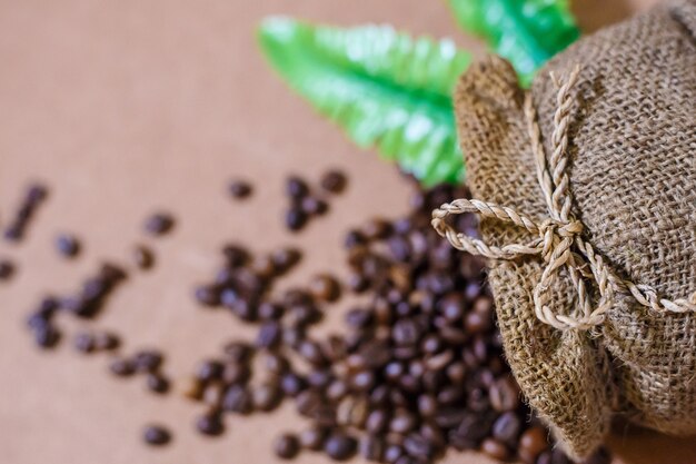 Foto cierre la bolsa de arpillera de café y desenfoque los granos de café en la bolsa de arpillera de café