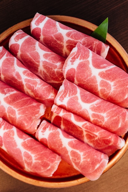 Cierre el cerdo Kurobuta (Cerdo Negro) Premium Rare Slices con textura de mármol bajo.