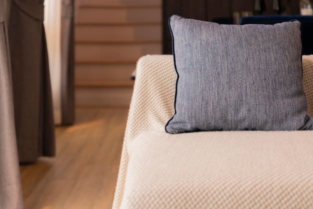 Cierre el cojín de la almohada decorativa arreglado con un patrón en un sofá beige suave en la sala de estar concepto de diseño de interiores para el hogar hogar dulce ideas para el hogar