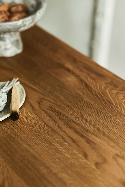 Cierre creativo composición de elegante mesa de comedor de madera. Hermosas decoraciones y accesorios para el hogar. Diseño interior de una casa moderna. Inspiración wabi-sabi. Plantilla.