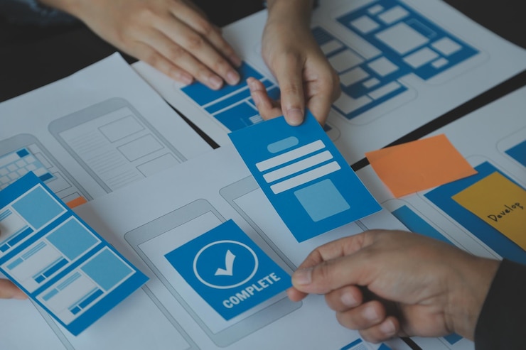 Foto cierre el desarrollador de ux y el diseñador de ui intercambiando ideas sobre el diseño de estructura alámbrica de la interfaz de la aplicación móvil en la mesa con el resumen del cliente y el código de color en la oficina modernaagencia de desarrollo digital creativa