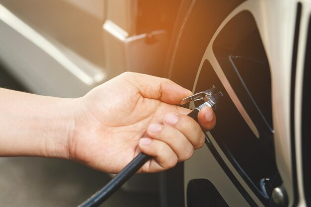 Cierre el estacionamiento del coche del hombre de la mano e infle el neumático llene el aire para una conducción segura sobre la marcha Concepto de vehículo de viaje de transporte