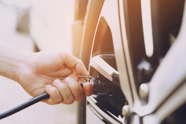 Cierre el estacionamiento del coche del hombre de la mano e infle el neumático llene el aire para una conducción segura sobre la marcha Concepto de vehículo de viaje de transporte