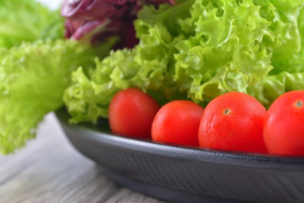 Cierre fresco de tomate cherry con ensalada de lechuga