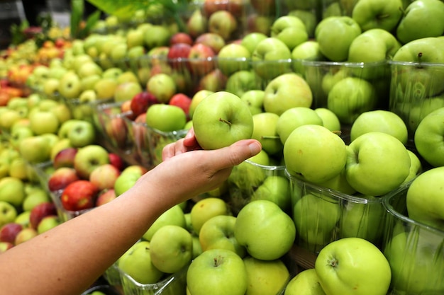 cierre de frutas de manzana orgánicas y verdes seleccionadas por el cliente en el supermercado