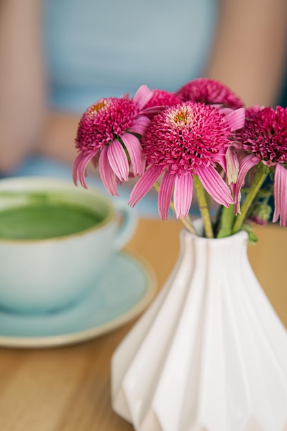 Cierre una gran taza de cerámica con una bebida de matcha verde sobre una mesa de madera