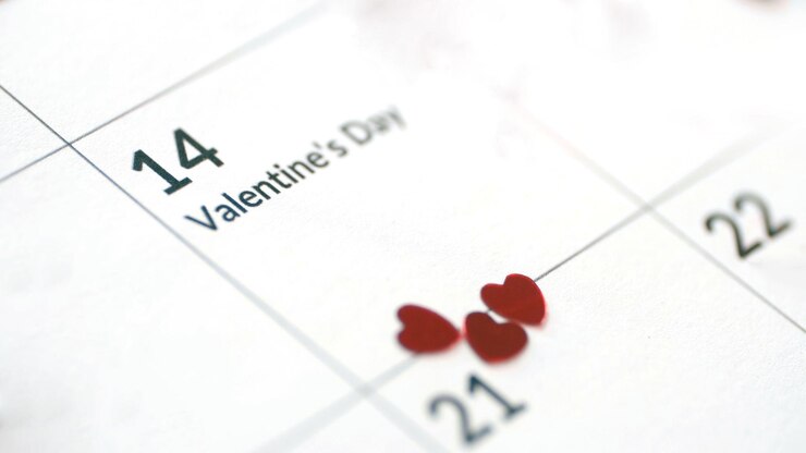 Cierre de la hoja de calendario del día de san valentín con fecha del 14 de febrero con corazones de papel rojo