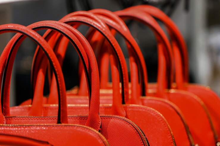 Cierre para manejar el bolso rojo de la mujer en la fila de la tienda de moda.