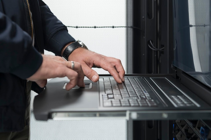 Foto cierre las manos del ingeniero del centro de datos usando el teclado en una supercomputadora. instalación especializada en salas de servidores con un administrador de sistemas masculino que trabaja con la red de protección de datos para la seguridad cibernética.
