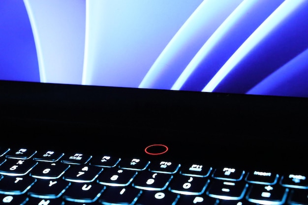 Cierre el monitor brillante y la foto del concepto de teclado retroiluminado Teclas negras con elementos iluminados