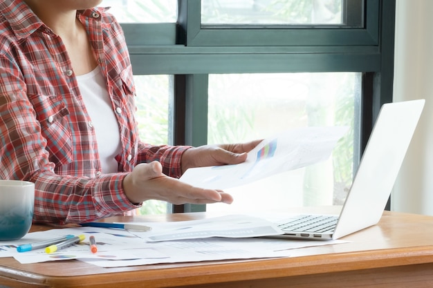 Cierre de la mujer de negocios que trabaja en la oficina y toma la decisión sobre las estadísticas del informe de venta