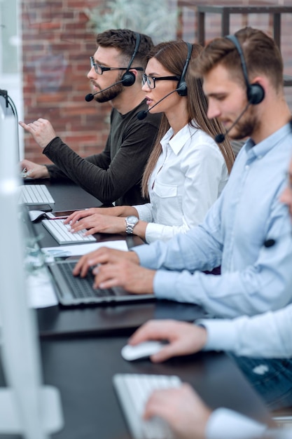 Foto cierre los operadores del centro de llamadas sentados en el concepto de negocio desk