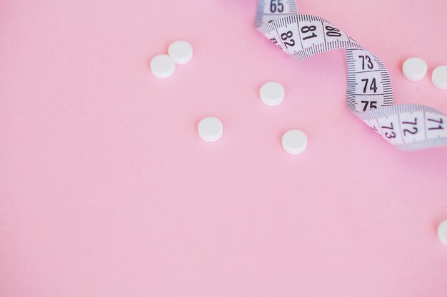 Cierre de pastillas. Suplementos dietéticos. Variedad de pastillas. Cápsulas de vitamina sobre fondo rosa