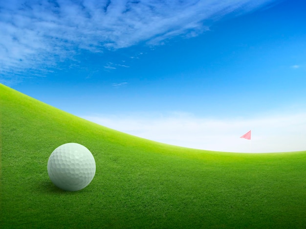 Foto cierre la pelota de golf en el campo de hierba verde y la bandera roja de golf en la calle verde con un hermoso cielo azul