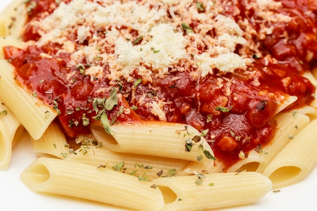 Cierre en penne con salsa roja y queso rallado, fondo negro