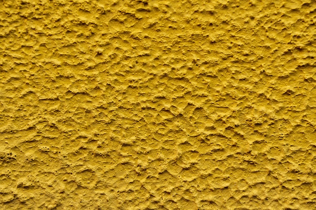 Cierre de textura áspera de fondo de color amarillo de pared