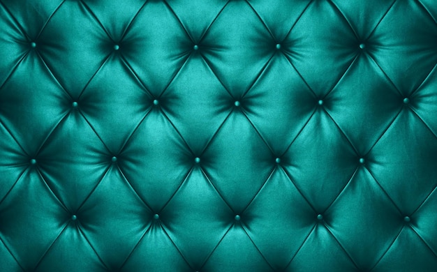 Cierre la textura de fondo de la tapicería de muebles capitoné azul turquesa teal de cuero genuino estilo Chesterfield retro con patrón de diamantes profundos y botones