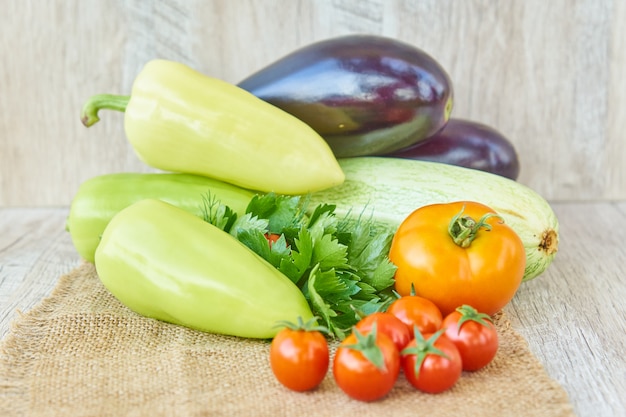 Ciérrese para arriba de la cosecha recientemente en vinagre de verduras - pimiento, taladro y tomates en la tabla de madera. Estilo rústico Concepto de comida orgánica saludable con espacio de copia