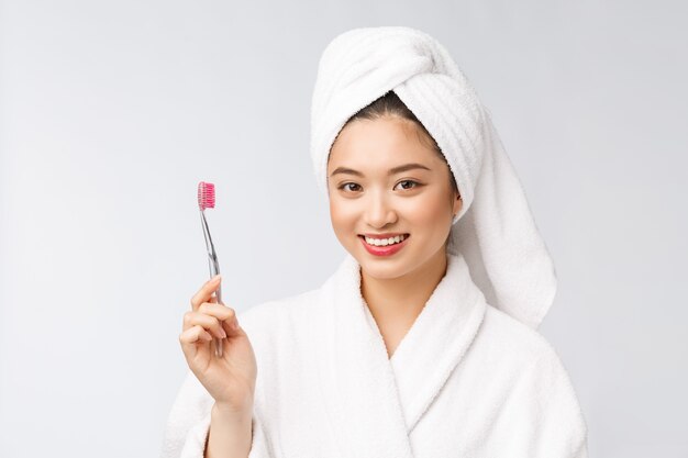 Ciérrese para arriba de los dientes del cepillo de la mujer de la sonrisa. ideal para el concepto de cuidado dental de salud, aislado sobre pared blanca. asiático.