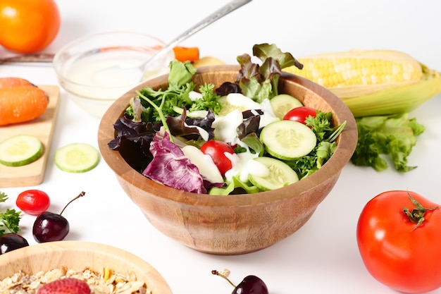 Ciérrese para arriba de la ensalada mezclada de las verduras en el fondo blanco.