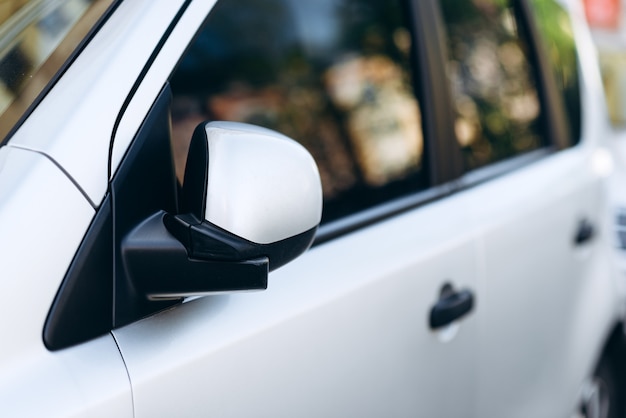 Ciérrese para arriba de un espejo del coche blanco.