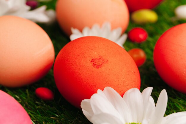 Ciérrese para arriba de los huevos y de los caramelos coloreados de Pascua en hierba