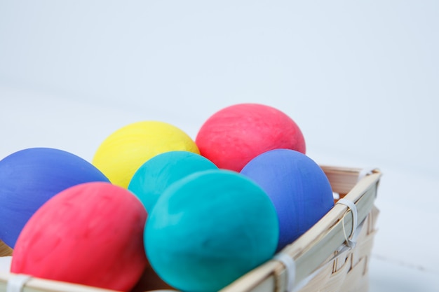 Ciérrese para arriba de los huevos de Pascua coloreados en cesta