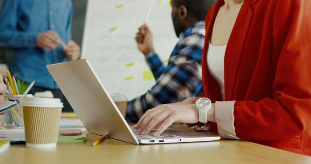 Ciérrese para arriba de la mujer joven que pulsa en el teclado de la computadora portátil. Concepto de estrategia de inicio.