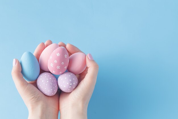 Ciérrese para arriba de la mujer que sostiene los huevos de Pascua coloridos