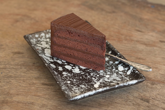 Ciérrese para arriba de la torta de chocolate cortada en el escritorio de madera