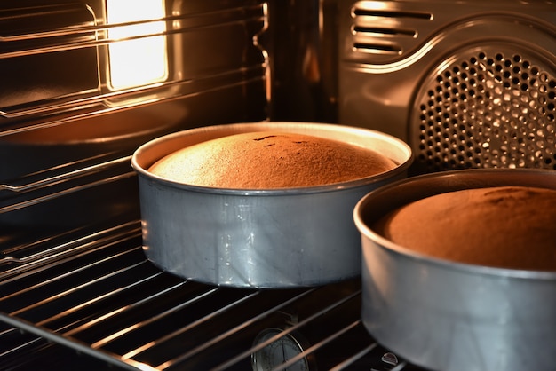 Ciérrese para arriba de las tortas de chocolate de hornada en el horno caliente, torta hecha en casa.