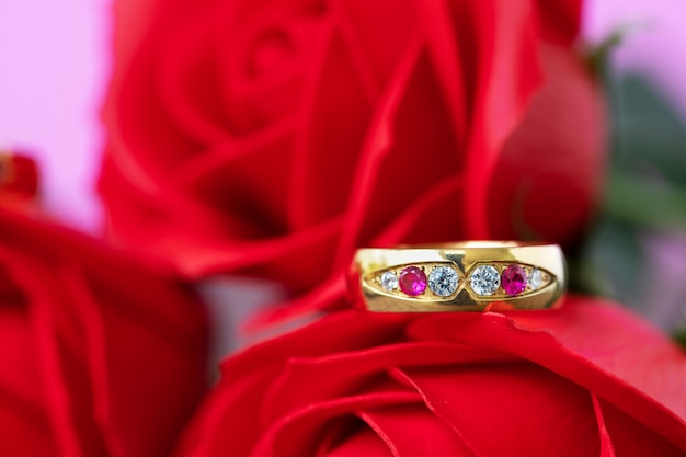 Ciérrese encima del anillo de bodas y de la rosa roja