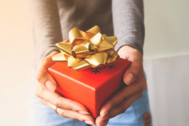 Ciérrese encima de la caja de regalo en las manos de la mujer. Acción de Gracias o Navidad