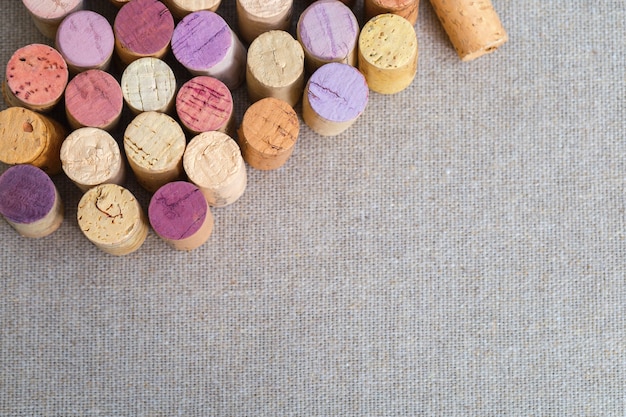 Ciérrese encima de corchos de las botellas de vino en fondo de la tela de lino.