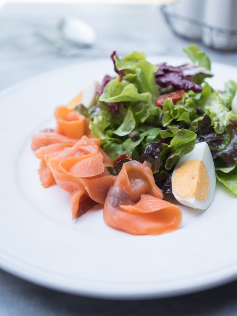 Ciérrese encima de la ensalada de color salmón del humo en la tabla.