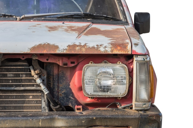 Ciérrese encima del frente del coche oxidado viejo aislado en el fondo blanco