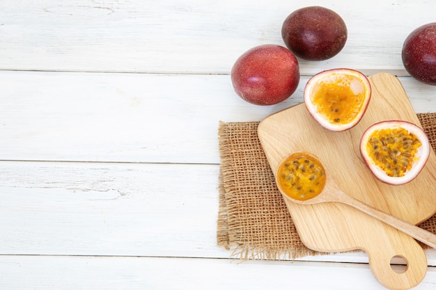 Ciérrese encima de una fruta de la pasión fresca en el fondo blanco de tabla de madera